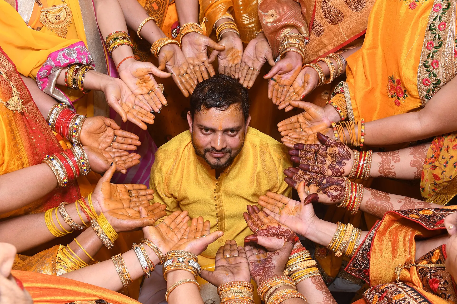 Mehendi hands surrounding the groom